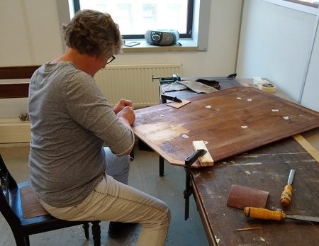 Restauratie van kromgetrokken tafelblad met profielen.